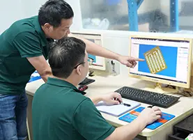 Engineering team reviewing 3D CAD models to optimize CNC machining paths for custom glass fabrication
